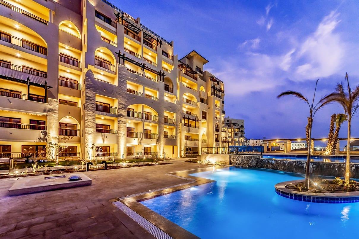 ALDAU Heights buildings and communal swimming pool at dusk