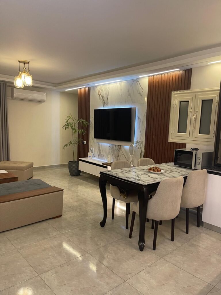 Dining table beside a television feature wall
